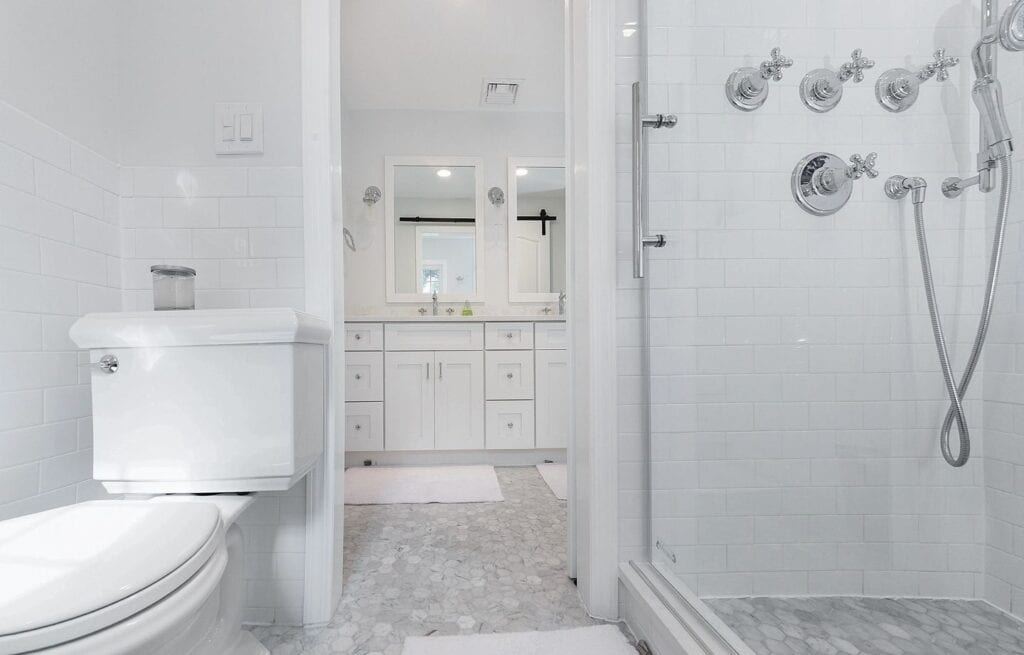 a spacious bathroom with white walls and fixtures