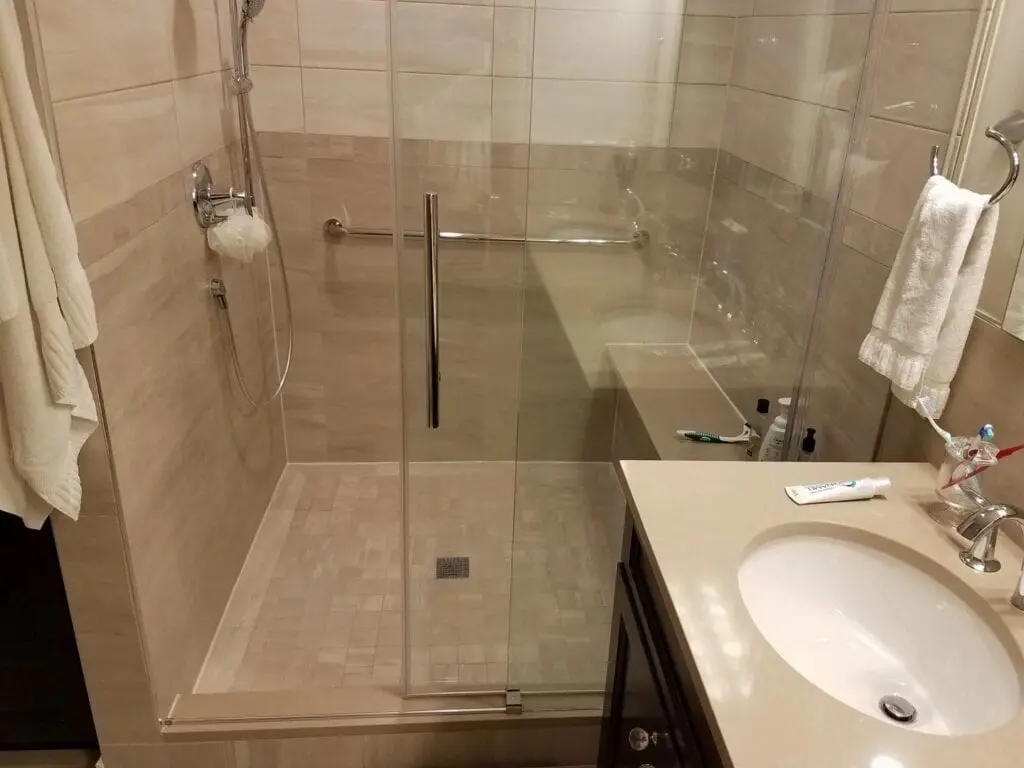a sink and shower area with a bench