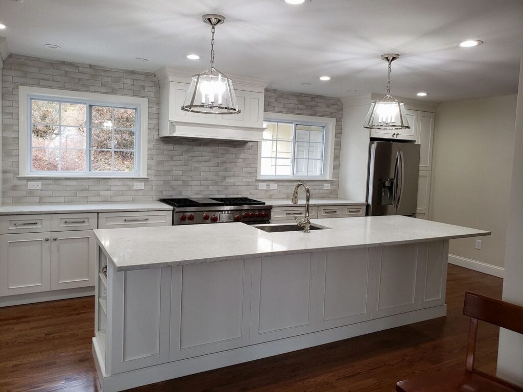 A spacious kitchen with a large marble counter with a sink